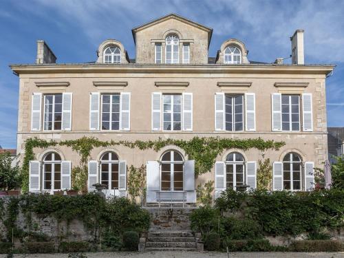 丰特奈勒孔特Chambre d'hotes La maison de Maître的一间大型房屋,设有白色窗户和常春藤