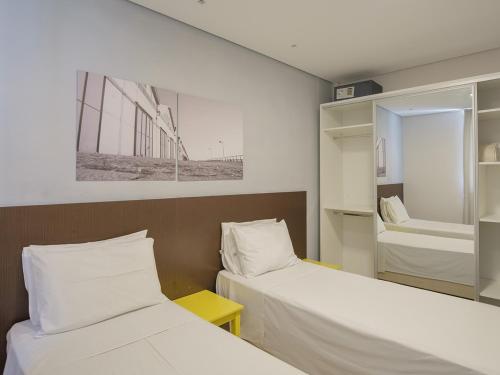 阿雷格里港Açores Flat Design- Ao lado da Casa De Cultura Mário Quintana的小房间设有两张床和镜子