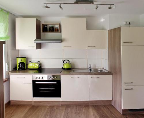 莱比锡Villa LE的厨房配有白色橱柜、水槽和炉灶。