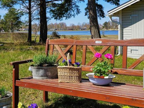 Bergkvara6 person holiday home in BERGKVARA的木板凳上放着鲜花和篮子