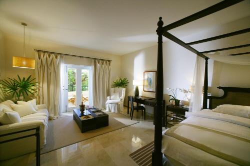 圣斐利-银港卡萨殖民海岸温泉酒店的一间卧室配有一张床、一张桌子和一张沙发