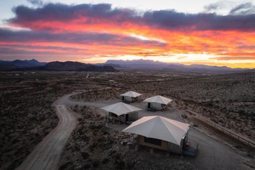 特灵瓜Camp Elena - Luxury Tents Minutes from Big Bend and Restaurants的日落时分沙漠帐篷的空中景观