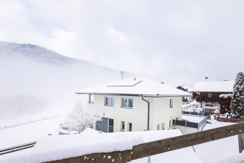 皮茨河谷阿兹尔Haus Raich - Pitztal Card im Sommer inklusive的屋顶上白雪的房子