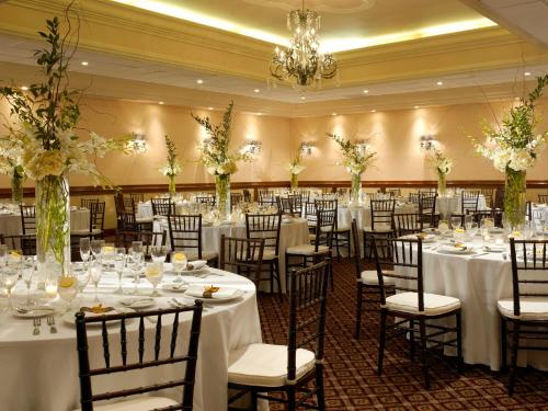 迈阿密海滩迈阿密海滨假日酒店的宴会厅配有桌椅和白色的桌布