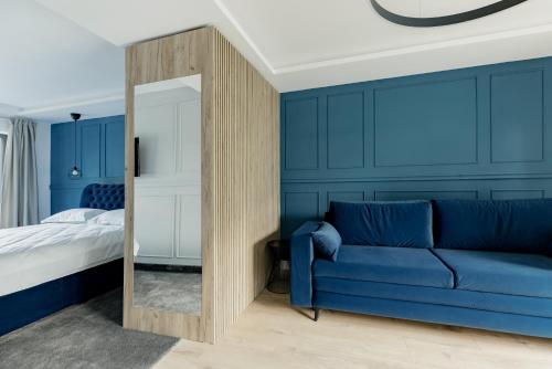 克卢日-纳波卡Aparthotel Nest Inn Meteor的蓝色的卧室配有蓝色的沙发和镜子