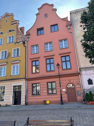 格鲁德柴兹Studio w Rynku的街上有一座红色的建筑,上面有一座大塔楼