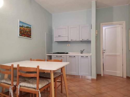 波多博罗Villetta Trilocale con Giardino 1.3的厨房配有桌椅和白色橱柜。