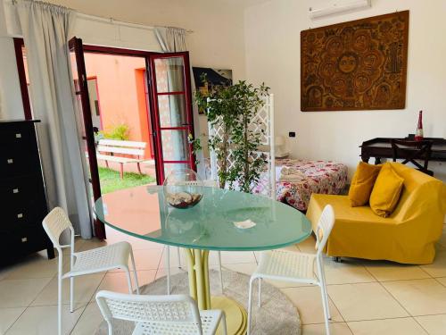 蒂勒尼亚Regina Del Mare Holiday Apartments的客厅配有玻璃桌和黄色沙发