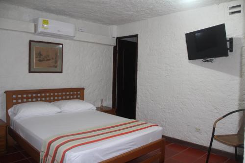 哥伦比亚港Villa Margarita的一间卧室配有一张床和一台平面电视