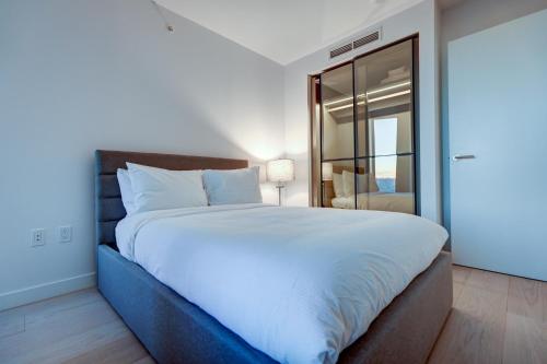 温哥华Downtown Properties的卧室配有一张白色大床和镜子