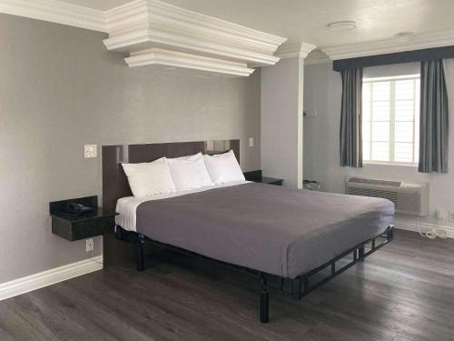 格伦代尔Motel 6 Glendale CA Pasadena Burbank Los Angeles的卧室配有带白色枕头的大床