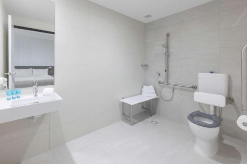 墨尔本Best Western Queen Victoria Market Hotel的白色的浴室设有卫生间和水槽。