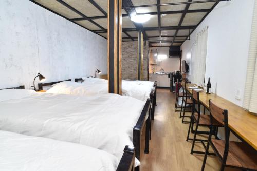 小樽Motel inn Minami Otaru / Vacation STAY 50438的一间设有一排白色床的房间和一间酒吧