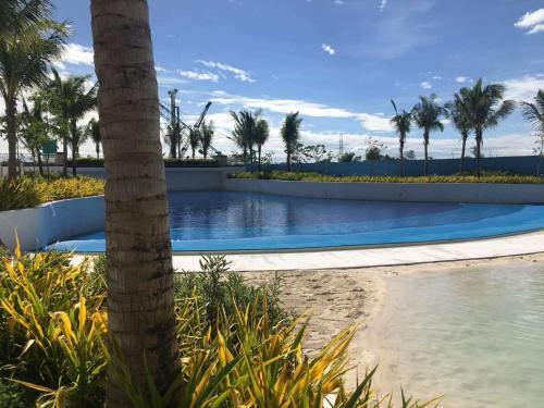 圣费尔南多GBU's Studio with Balcony at Azure North Pampanga的前方的游泳池,有棕榈树