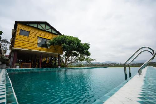 峰牙Greenfield Ecostay的一座房子,旁边设有游泳池