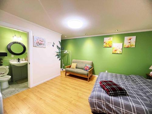 萨里Separate access suite , separate kitchen, bathroom的一间带绿色墙壁和一张床的卧室以及一间浴室。