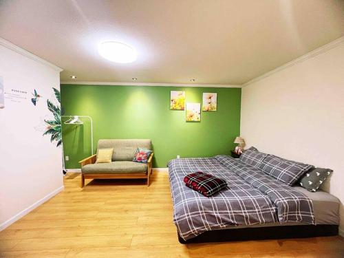 萨里Separate access suite , separate kitchen, bathroom的一间卧室设有绿色的墙壁、一张床和椅子