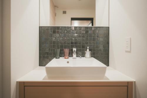 广岛NAGI Hiroshima Hotel and Lounge的浴室设有白色水槽和镜子