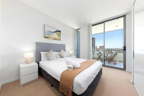 悉尼Skyview Comfy Apt in Centre of Burwood的一间卧室设有一张床和一个大窗户