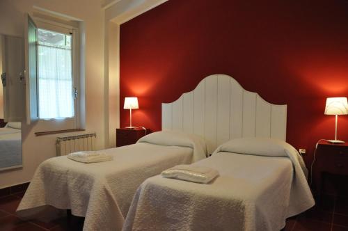 卡尔伦蒂尼里卡蒂亚农场酒店的红色墙壁客房的两张床