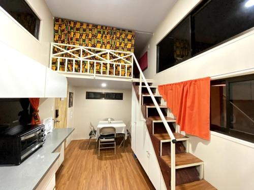 别霍港Tiny house with extended camping area for large groups的一个小房子,有楼梯和饭厅
