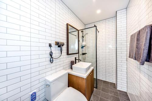 济州市The Jade Hotel的一间带卫生间、水槽和镜子的浴室
