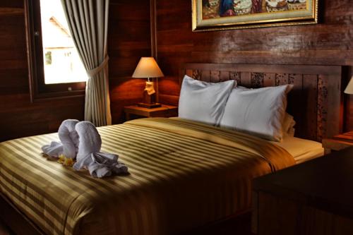 丹戎米娜丹绒假日公园的一间卧室配有一张带毯子的床和窗户