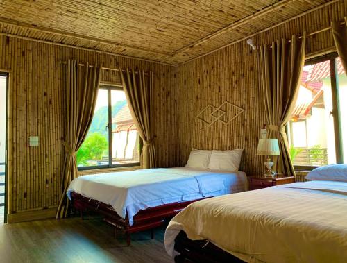 宁平Tam Coc Mandala Villa的一间卧室设有两张床和窗户。