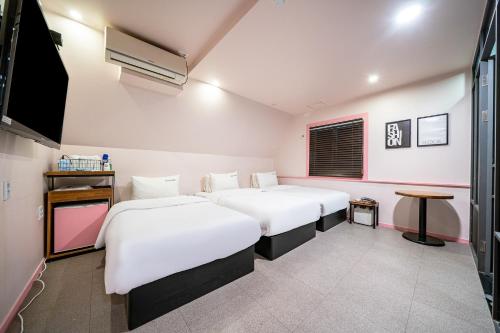 釜山No25 Hotel Yeonsan的客房设有两张床和一台平面电视。