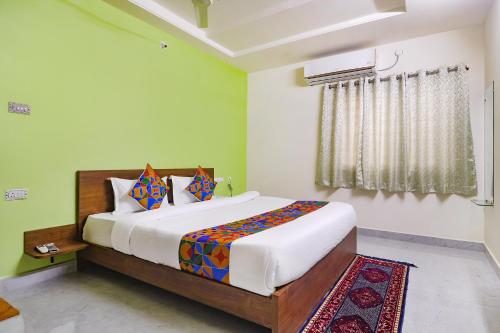 海得拉巴FabHotel Golden Hitech的一间卧室设有一张大床和一个窗户。