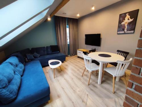 米卢夫卡Apartament Nad Góralem的客厅配有蓝色的沙发和桌子