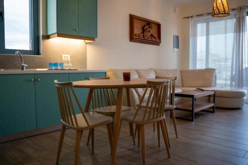 科斯镇Sea and city apartments的厨房以及带桌椅的起居室。