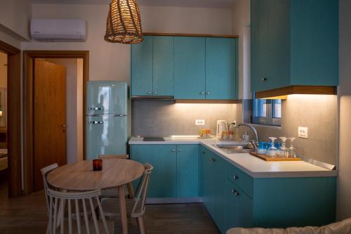 科斯镇Sea and city apartments的厨房配有蓝色橱柜和木桌