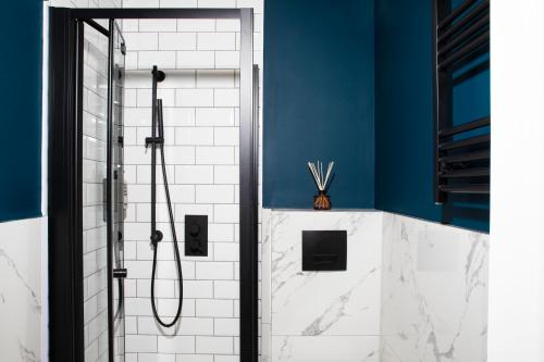 伦敦Bob W Hyde Park的浴室设有蓝色墙壁和白色瓷砖,配有淋浴。