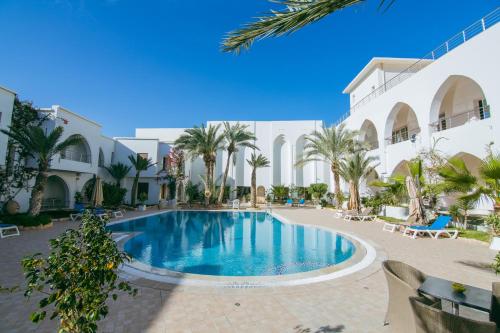 迈来亚Palm Djerba Suites的棕榈树酒店庭院内的游泳池