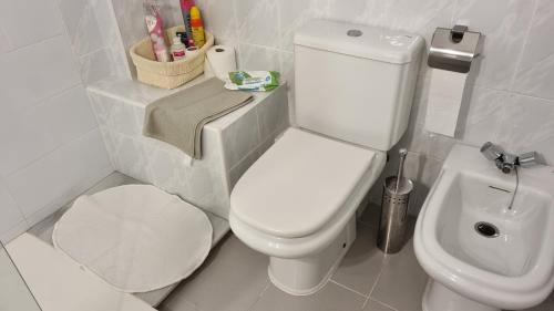 韦尔瓦Hoyo 12 Islantilla的浴室配有白色卫生间和盥洗盆。