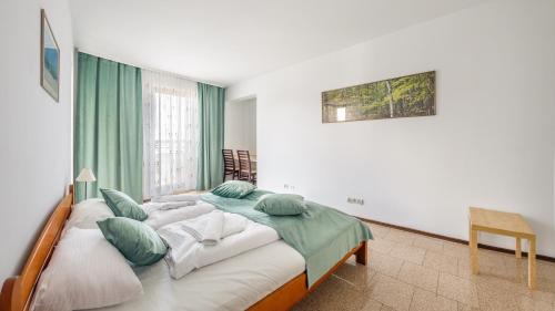 米兹多洛杰Apartamenty Sun & Snow Marea的一间卧室配有一张带绿色窗帘的大床