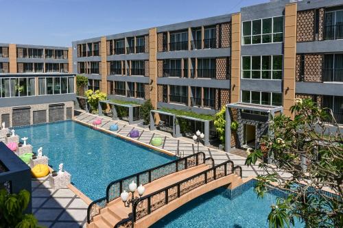 华欣Golden Sea Hua Hin - SHA Extra Plus的公寓大楼前方设有游泳池