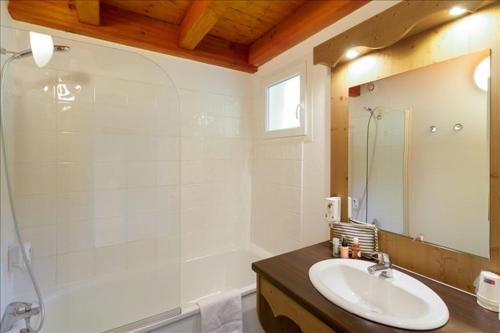 吕格兰Duplex-Chalet entre Lac et Montagne - Balcon Vue Lac的浴室配有水槽、淋浴和浴缸。