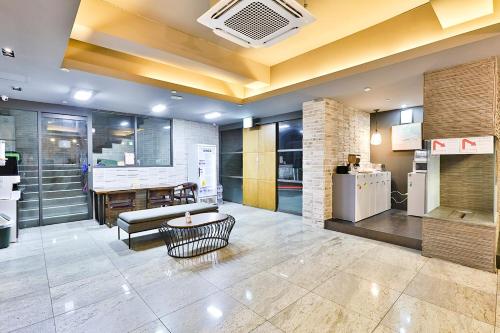 釜山Seomyeon Hound Hotel 1st Street的大堂配有沙发、桌子和冰箱