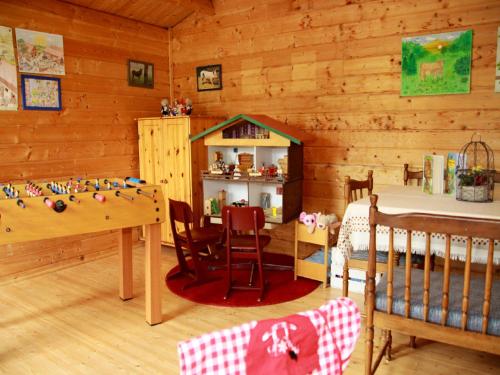 HeimenkirchAndreashof的一间设有一张婴儿床和一张桌子的房间以及一间卧室
