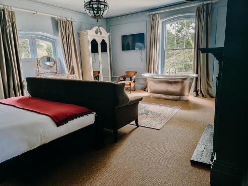 莱德伯里Verzon House的一间卧室配有一张床、一把椅子和一个浴缸