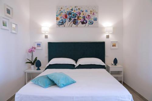 阿莱萨诺Tenuta Cesarina的一间卧室配有白色的床和2个蓝色枕头
