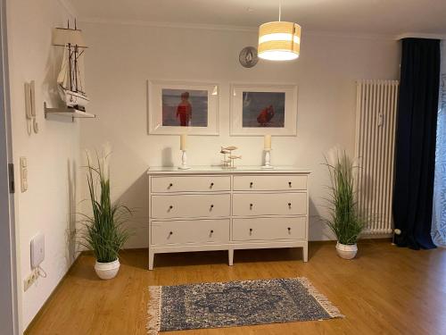 奥斯赛拜-屈隆斯博恩Appartementanlage Ostseeblick的一间两棵植物的房间的白色梳妆台
