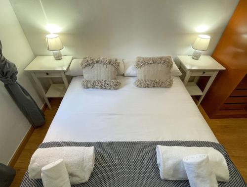 萨拉戈萨AZ El Balcón de Luna的一张大白色的床,位于带两张桌子的房间