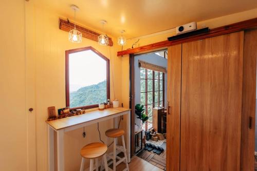Ban Huai KhaiAt The Mountain Cottage, Tiny Home at Doichang with Hot tub Included Breakfast and Dinner的厨房配有柜台和窗户。