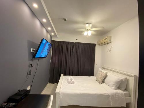 佩塔提克瓦Rothschild 79的一间卧室配有一张床和一台平面电视