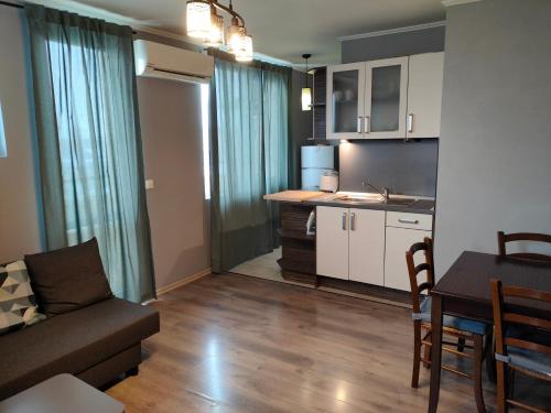 索非亚Mladost 1 Apartment near the metro的带沙发和桌子的客厅以及厨房。