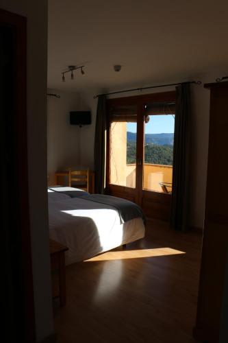 La Morera de MontsantHotel Balcó del Priorat的一间卧室设有一张床和一个大窗户