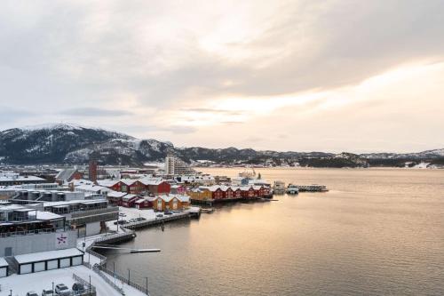 纳姆索斯斯堪迪克岩城酒店的水面上的城镇,有雪覆盖的建筑